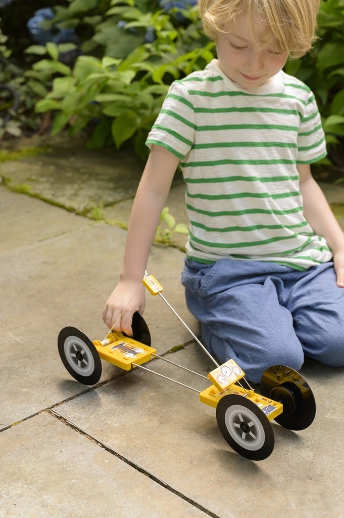 ילד משחק במכונית הרכבה על קפיץ